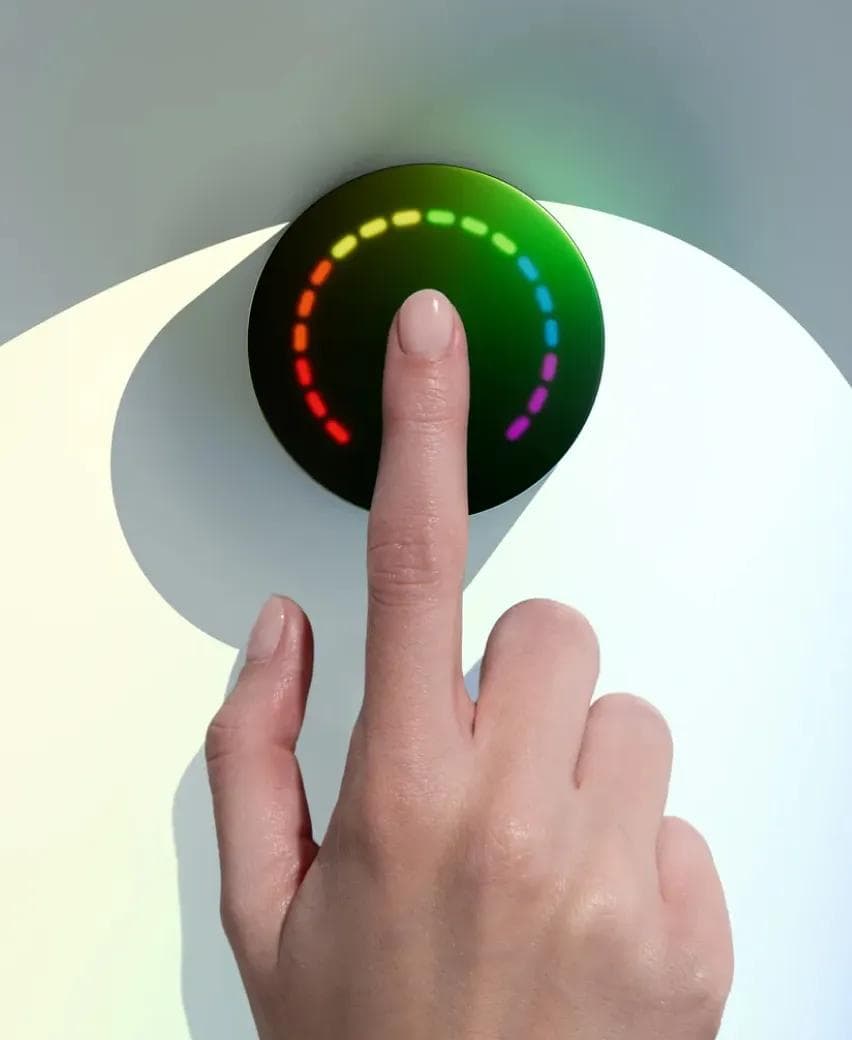 A finger held on the Prysm iO scanner, its ring of light showing a reading
